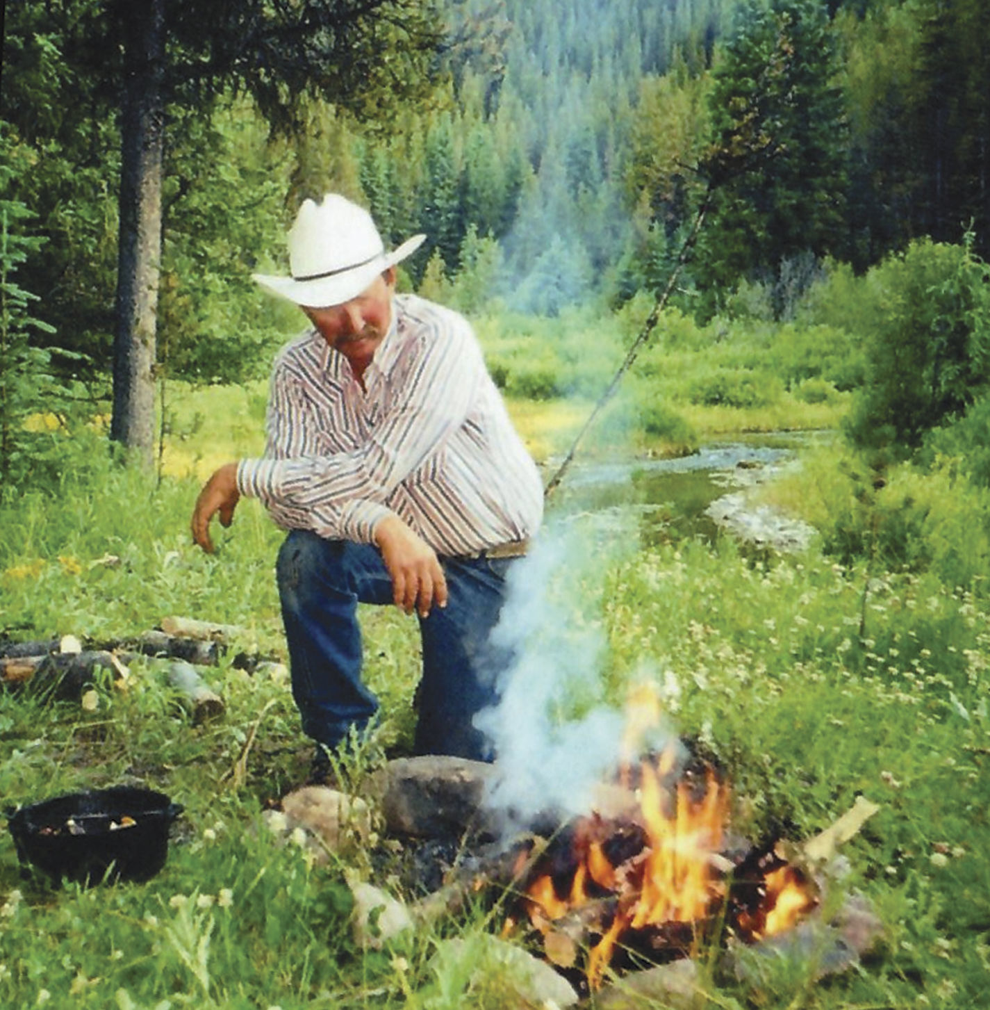 Ron Mills tends a backcountry campfire.